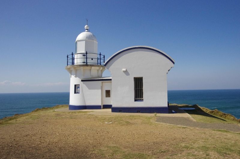 A white and blue trimmed lighthouse overlooking the ocean. Located at Tacking Point, Port Macquarie, NSW, Australia.